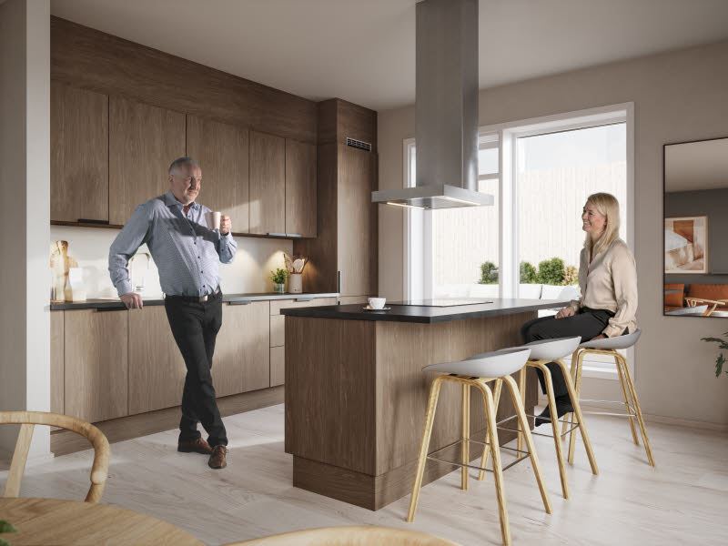 Bilde fra leilighet i boligprosjektet Skårerløkka PREMIUM. Leiligheten er lys beige og viser en mann og en dame som tar en kaffekopp sammen på kjøkkenet.