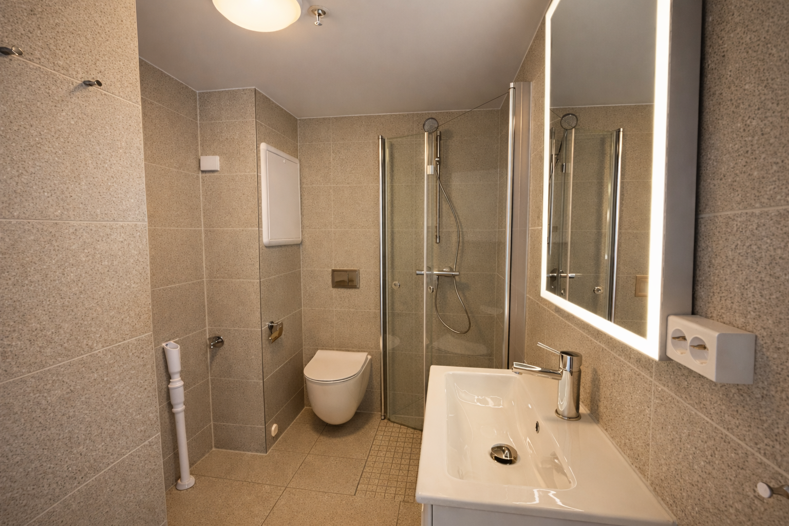 Moderne og helhetlig baderom med flislagte overflater, dusjkabinett og stilrene detaljer – utformet for en praktisk og komfortabel hverdag.