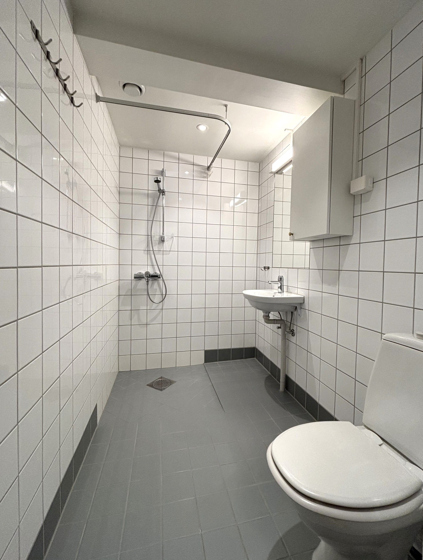 Flislagt bad med dusj og varmekabler.